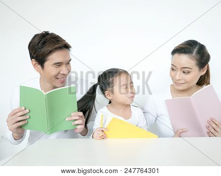 Attractive Asian Family Holding Book Together. Happy Family Concept.