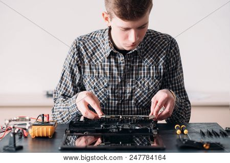 Microelectronics. Computer Renovation In Repair Shop. Engineer Inspecting Motherboard Of A Diassembl