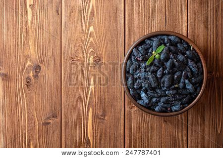 Honeysuckle Berries Or Lonicera Caerulea In Ceramic Bowl On Wooden Background