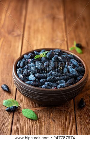 Honeysuckle Berries Or Lonicera Caerulea In Ceramic Bowl On Wooden Background