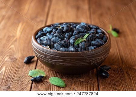 Honeysuckle Berries Or Lonicera Caerulea In Ceramic Bowl On Wooden Background