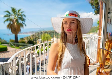 Beautiful Girl In A Shite Dress And Summer Hat Exploring The Old Town Of Taormina On Sicily Island.