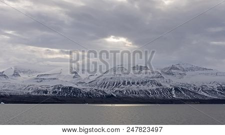 Sun Breaking Through The Ocean Clouds Along A Remote Coast Of Greenland Along The Nugssuaq Peninsula