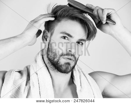 Man Takes Care Of His Hair. Bearded Man Or Handsome Macho With Bathing Towel On Neck Combing Healthy