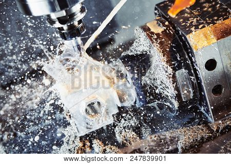 Milling metalworking process. Industrial CNC metal machining by vertical mill. Coolant and lubrication
