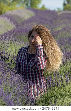 Ostrow, Poland - June 6, 2018: Beautiful  Woman With Long Curly Hair In The Middle Of A Lavender Fie