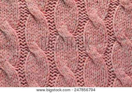 Knit Texture Of Pink Wool Knitted Fabric With Regular Cable Knitted Pattern. Blank Background