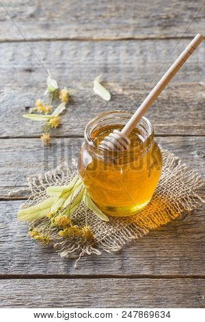 Glass Jar Of Honey, Linden Flowers On Wooden Background