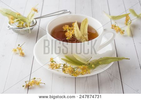 Cup Of Tea With Linden Flowers On A Light Table