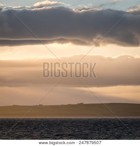 A Hazy Telephoto View Of The Island Of Stroma Off The Northerly Coast Of Scotland Contrasting Agains