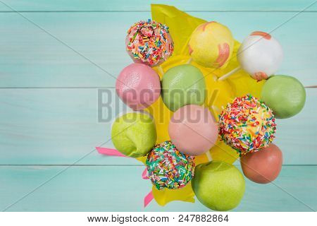 A Lot Of Colored Pop Cakes In A Glass On Turquoise Boards, Top View