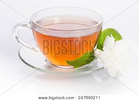Glass Cup Of Tea With Jasmine Flowers And Leaves