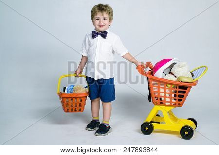 Shopping, Discount, Sale Concept - Cheerful Little Boy With Shopping Cart And Basket. Kid Plays In S