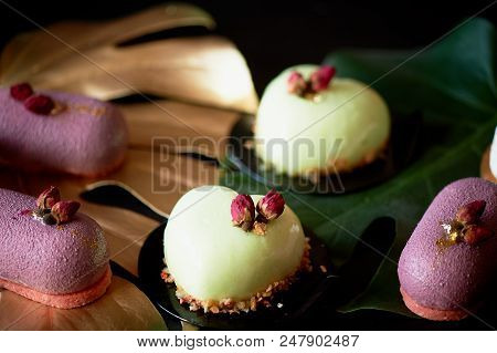 Moscovie Cakes Purple And Lemon Yellow. Pistachio And Fruit. Culinary Art. Gold Leaf Monstera