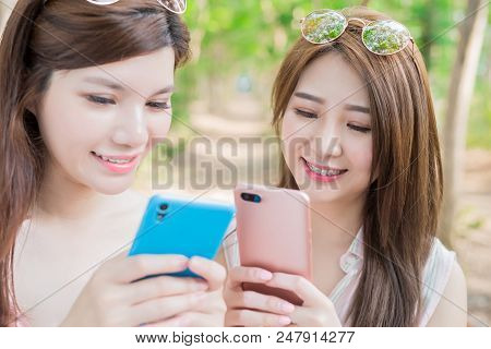 Two Beauty Women Smile With Braces And Use Phone Happily