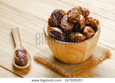 Dried Dates Plam Fruit In Wooden Bowl On Table