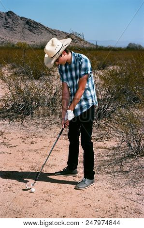 Young Boy In Natural Terrain Desert Golfing