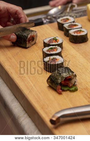 Sushi Roll Being Sliced In A Demonstaration Class