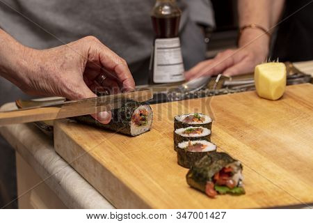 Sushi Roll Being Sliced In A Demonstaration Class