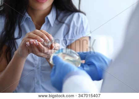 Close-up Of Male And Female Hands Holding Breast Silicone Implants. Physician In Blue Sterile Gloves