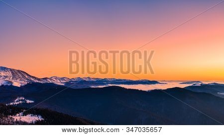 Mountain Range With Visible Silhouettes Through The Morning Colorful Fog.tarcu Mountains In Romania.