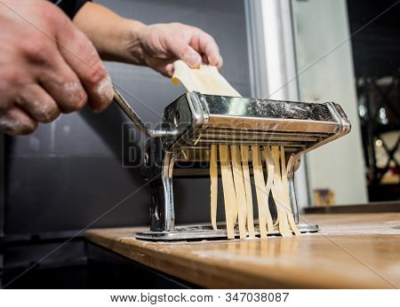 Chef Rolling Dough With A Pasta Machine. Pasta Maker Machine.