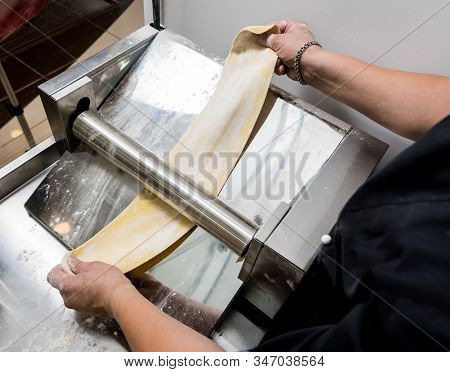Chef Rolling Dough With A Pasta Machine. Pasta Maker Machine.