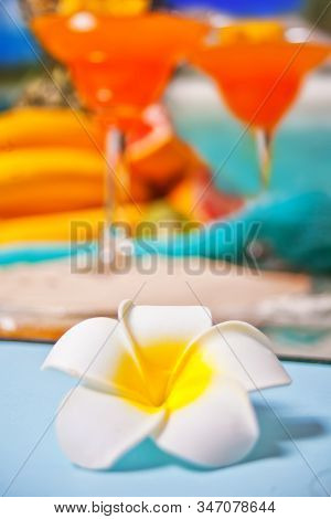 Plumeria Frangipani Flower And Glasses Of Tropical Exotic Multifruit Juice Cocktail Drink On The Bac
