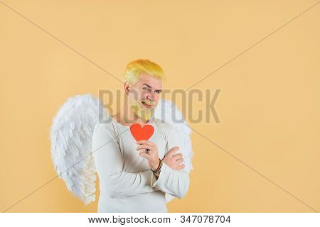 Cupid Holds Valnetine's Heart. Handsome Angel Cupid. Love Concept. Valentine Angel. Bearded Man With
