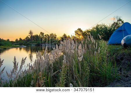 Morning Dawn On Night Camp Of Tourists Or Fisherman After Rafting On River By Boat. Tourist Tent Nex