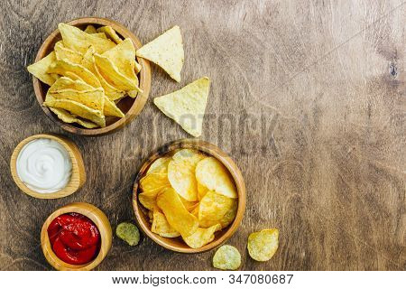Table Fof Tasty Snacks And Beer Prepared For Watching Sports On Tv. Wooden Background. Top View. Fla