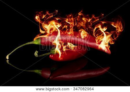 Group Of Two Whole Hot Red Chili Burning Fire Isolated On Black Glass