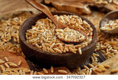 Raw Kamut Grain In A Wooden Bowl With A Spoon