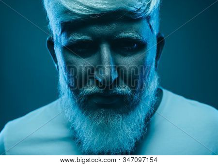 Brutal Tense Determined Bearded Male With Albinism Standing In Studio With Blue Neon Light And Looki