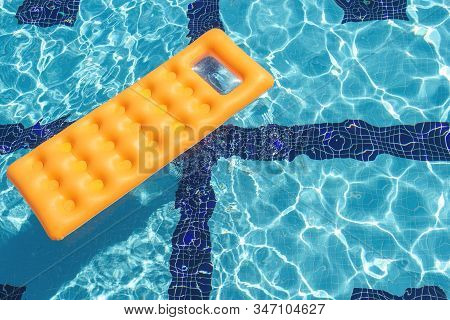 Floating Orange Air Mattress In Swimming Pool