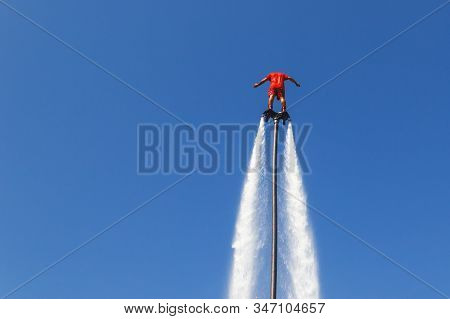 Fly Board, Man On A Flyboard In Red. New Sport And A Stunning Mechanism For Extreme Recreation And E