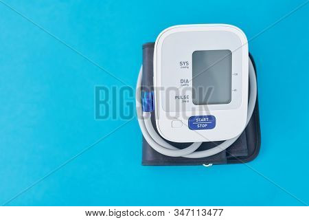 Digital Blood Pressure Monitor On A Blue Background, Closeup. Helathcare And Medical Concept