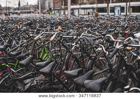 Big Bicycle Parking With Lot Of Bicycles, Rayny Day, Iconic Transport In Amsterdam.