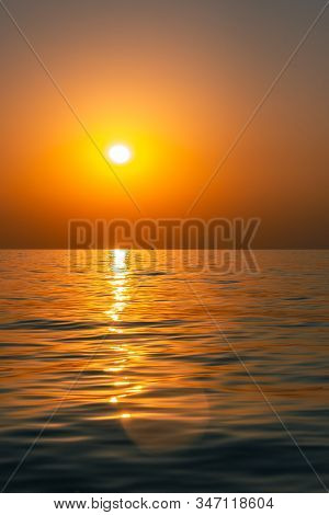Bright Sunset With Large Yellow Sun Under The Sea Surface. Beautiful Sunset Over The Sea.