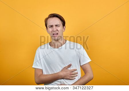 Stomach Pains Stomach Problems White T-shirt Young Male On Yellow Background