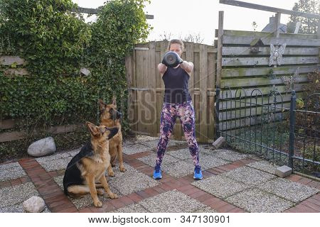 Young Woman Do Exercises With Jumping Rope, Two German Sheppards Watch