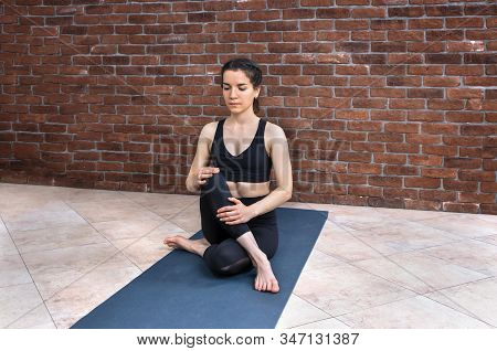 Sporty Brunette Woman Practicing Yoga, Doing Gomukasana Exercise, Cow Face Pose, Working Out, Wearin