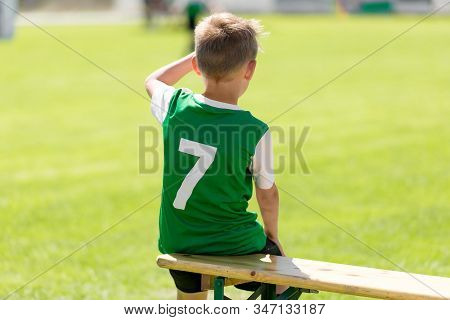 Soccer Boy In Grean Jersey Shirt Sitting On Wooden Bench