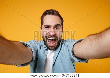 Close Up Of Crazy Young Man In Blue Shirt Posing Isolated On Yellow Orange Background. People Lifest