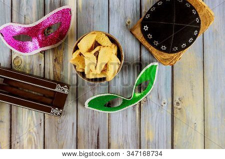 Traditional Jewish Carnival Holiday Purim Celebration And Cookies Hamans Ears, Noisemaker And Mask H