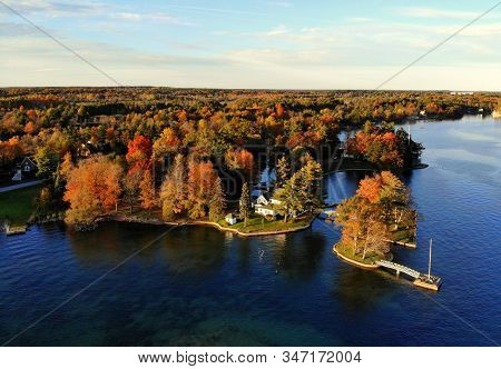The Aerial View Of The Waterfront Residential Area Surrounded By Striking Fall Foliage By St Lawrenc