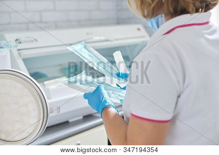 Female Nurse Doing Sterilization Of Dental Medical Instruments In Autoclave. Sterilization Departmen