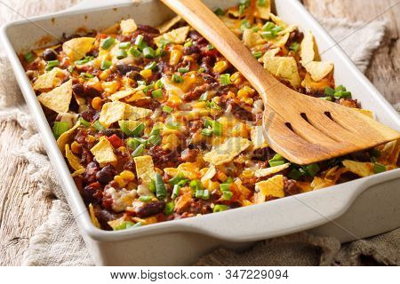Freshly Baked Frito Pie With Ground Beef, Cheese, Corn, Beans And Chips Close-up In A Baking Dish. H