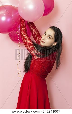 Young Pretty Woman In Red Evening Dress Holding Festive Air Balloons. Portrait Of Happy 20s Middle-e