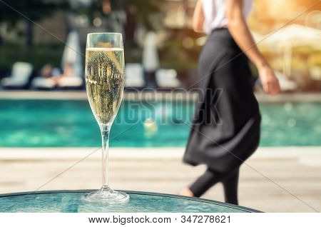 Close-up White Champagne Or Prosecco Glass Against Poolside At Luxury Resort Hotel During Vacation. 